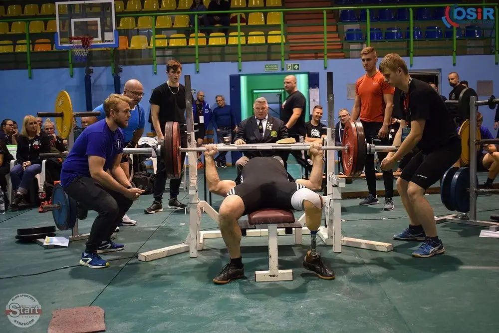 Główna sala hali sportowej na której odbywają się zawody w wyciskaniu sztangi leżąc z dużą publicznością.